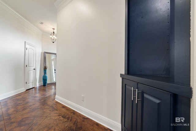 hall featuring crown molding, an inviting chandelier, and dark tile patterned floors