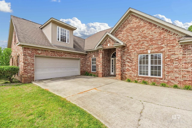 view of property featuring a garage and a front lawn