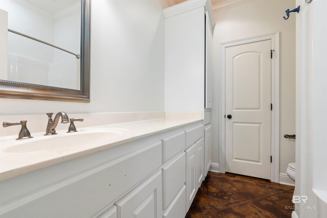 bathroom featuring vanity, toilet, and ornamental molding