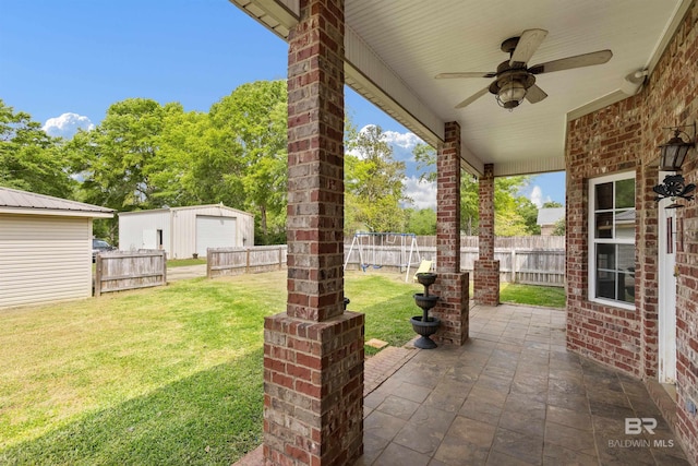 view of patio with ceiling fan, a garage, and an outdoor structure