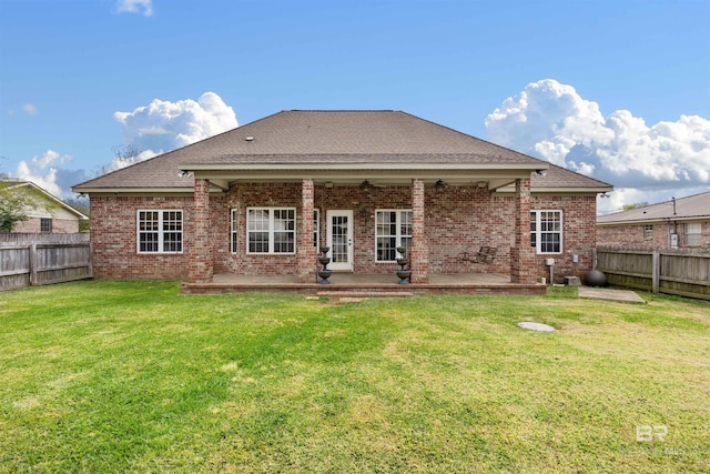 rear view of house featuring a yard and a patio