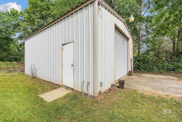 view of outbuilding featuring a lawn and a garage