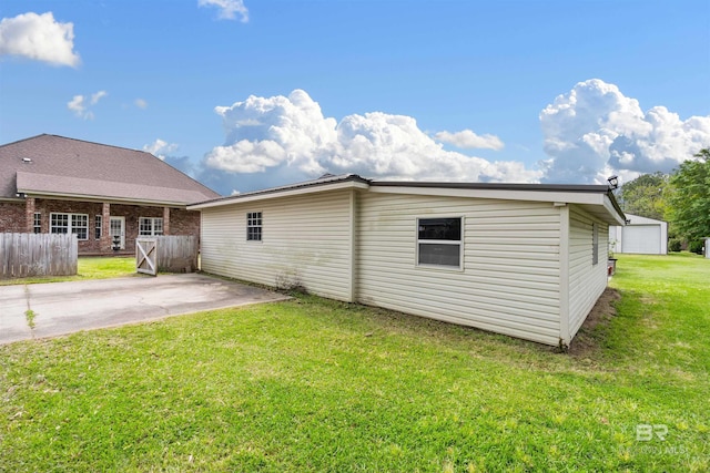 rear view of property featuring a patio area and a lawn