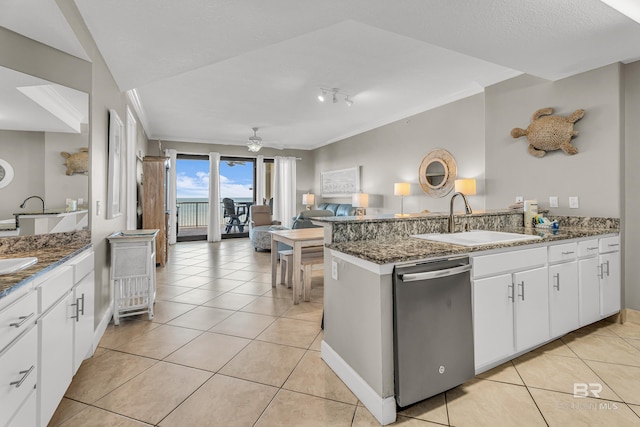 27284 Gulf Rd Unit 711, Orange Beach, AL 36561 - kitchen featuring dishwasher, a sink, a peninsula, light tile patterned floors, and white cabinets