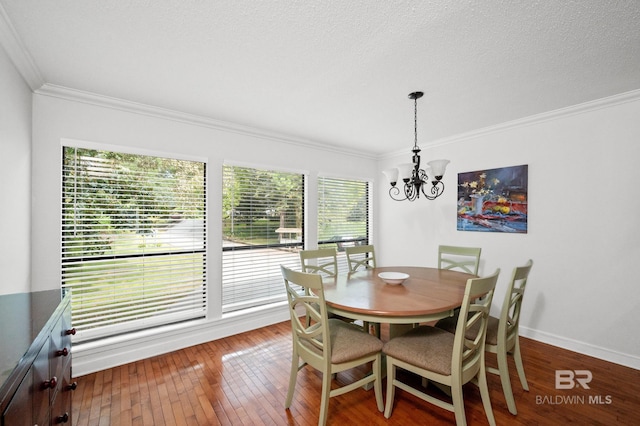 dining room featuring a healthy amount of sunlight, wood-type flooring, and a notable chandelier