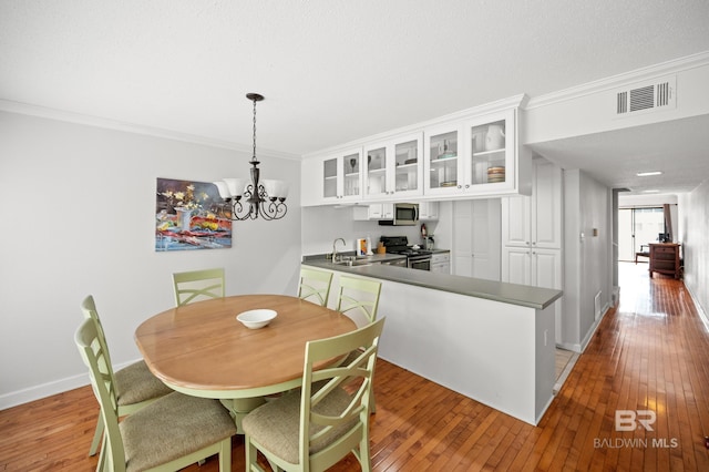 dining area with ornamental molding, sink, and hardwood / wood-style floors