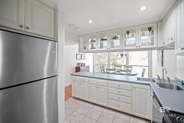 kitchen featuring stainless steel appliances, crown molding, light tile patterned floors, and white cabinetry