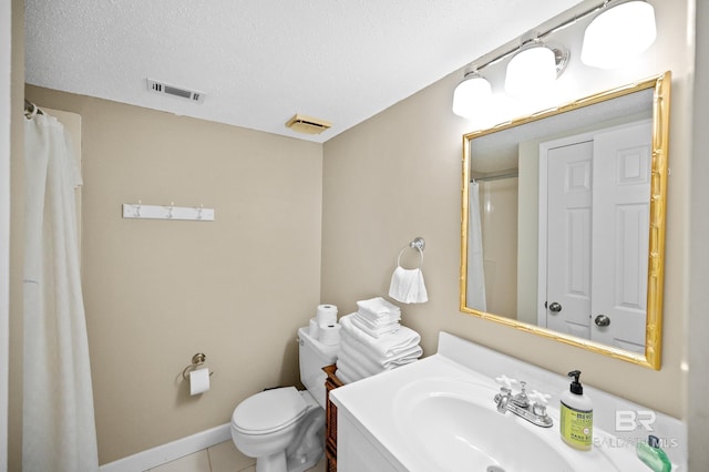 bathroom featuring vanity, toilet, a textured ceiling, and tile patterned floors