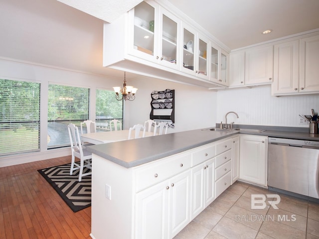 kitchen with light hardwood / wood-style floors, stainless steel dishwasher, and white cabinets