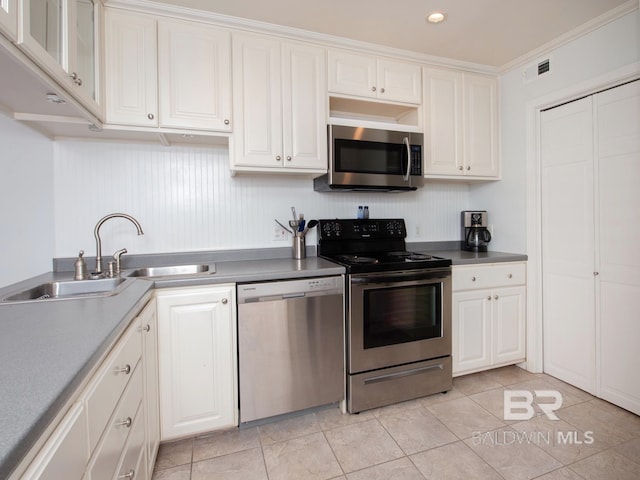 kitchen with white cabinets, light tile patterned flooring, appliances with stainless steel finishes, and sink