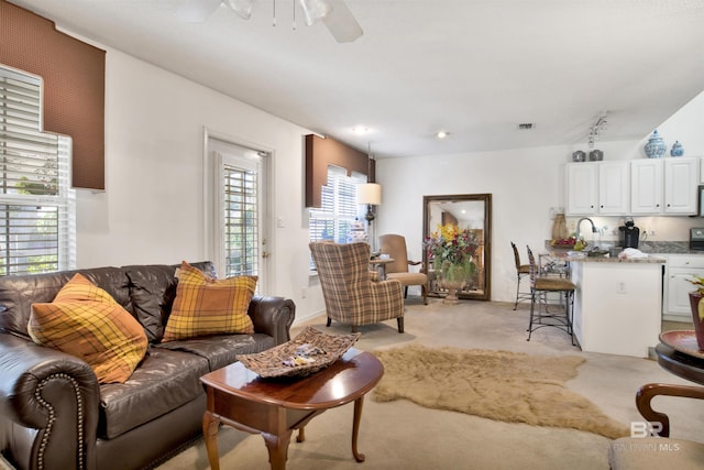 carpeted living room with ceiling fan