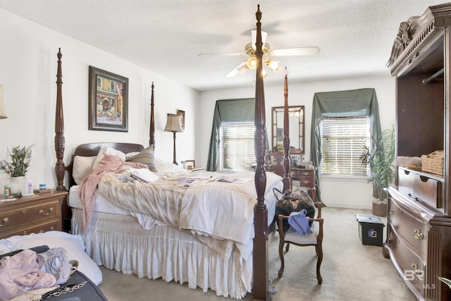 carpeted bedroom with ceiling fan, a textured ceiling, and multiple windows