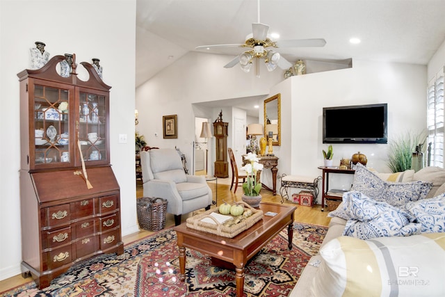 living room with ceiling fan, light hardwood / wood-style flooring, and lofted ceiling