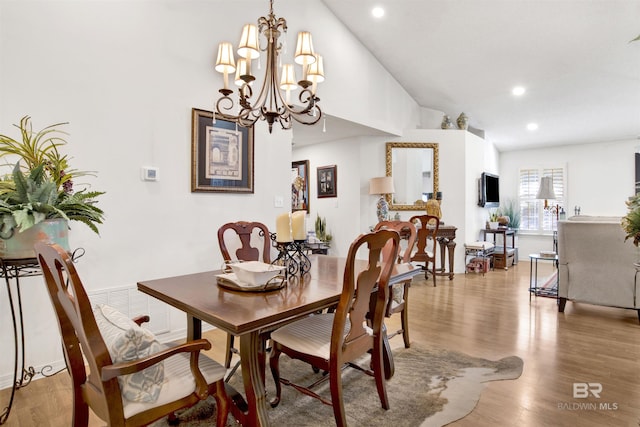 dining room featuring a notable chandelier, high vaulted ceiling, and light hardwood / wood-style flooring