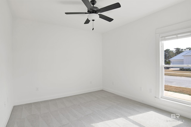 spare room with light colored carpet and ceiling fan