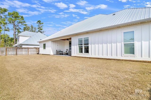 back of property featuring ceiling fan, a patio, and a lawn