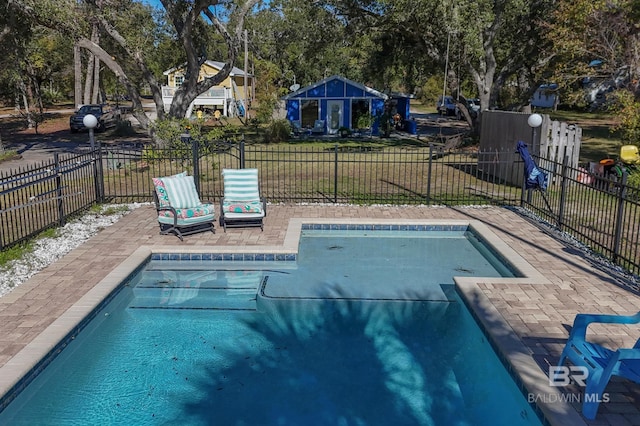 view of pool with a lawn and a patio