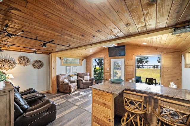 kitchen featuring light brown cabinetry, wood ceiling, dark wood-type flooring, vaulted ceiling with beams, and wood walls