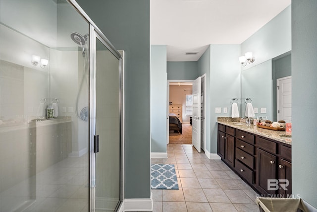 bathroom featuring a shower with door, vanity, and tile patterned floors