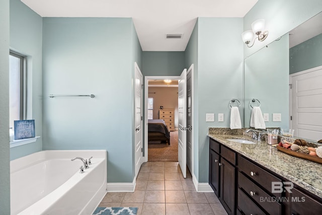 bathroom featuring vanity, a bath, and tile patterned floors