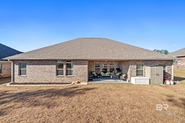 back of property featuring a lawn, a storage shed, and a patio