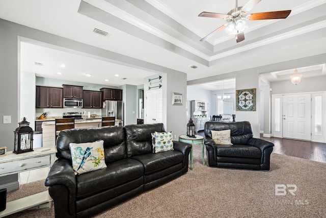 living room featuring crown molding, ceiling fan, dark hardwood / wood-style floors, and a tray ceiling