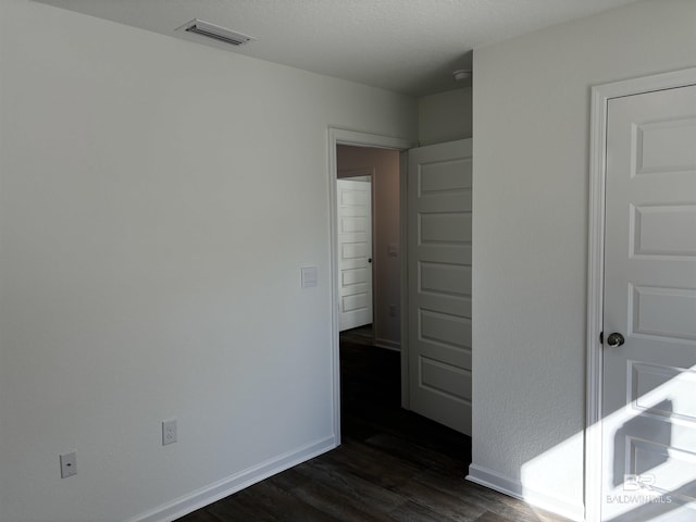 empty room with dark hardwood / wood-style flooring