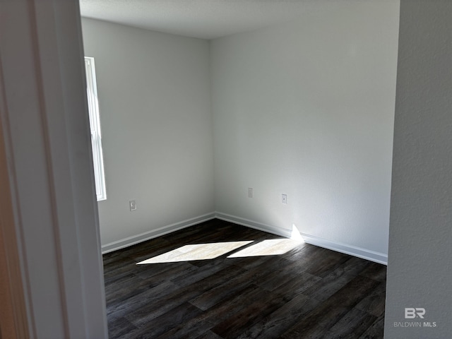 empty room with dark hardwood / wood-style flooring