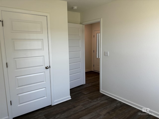 corridor with dark hardwood / wood-style floors