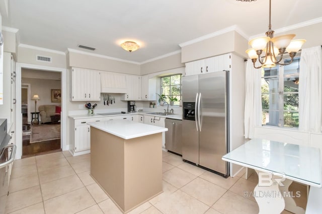 kitchen featuring a center island, stainless steel appliances, hanging light fixtures, and crown molding