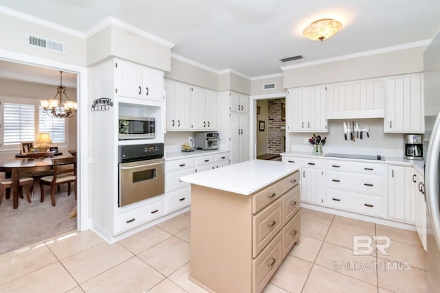 kitchen with a center island, stainless steel appliances, hanging light fixtures, and crown molding