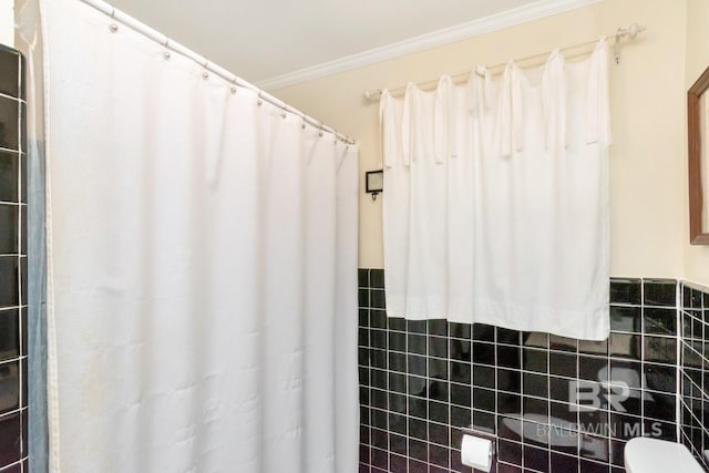 bathroom featuring ornamental molding and tile walls