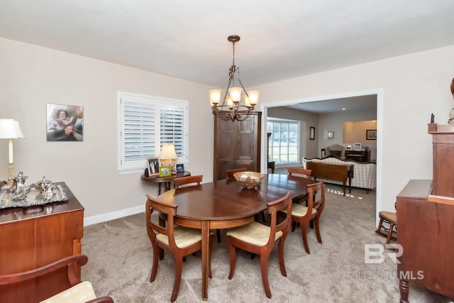 dining area with a notable chandelier and light carpet