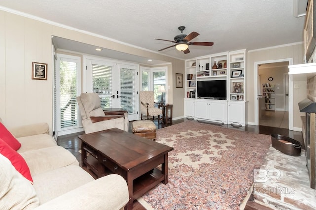 living room featuring french doors, ceiling fan, ornamental molding, a textured ceiling, and wood-type flooring