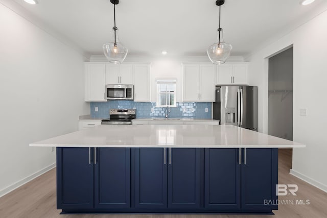 kitchen with blue cabinetry, appliances with stainless steel finishes, a sink, and tasteful backsplash