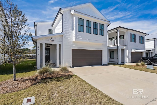 view of front of property featuring a garage, ceiling fan, a front lawn, and concrete driveway