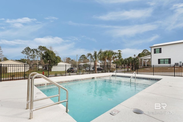 community pool with a patio area and fence