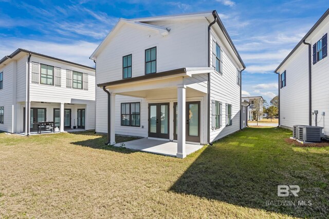 rear view of house with central AC, a yard, and a patio