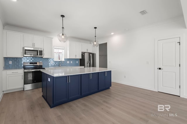 kitchen with a center island, blue cabinetry, stainless steel appliances, white cabinetry, and a sink