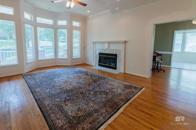 1619 Silver Creek Ct, Saraland, AL 36571 - living room with a ceiling fan, crown molding, a tiled fireplace, light wood-style floors, and recessed lighting