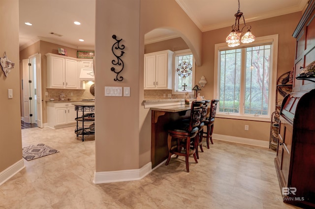 kitchen featuring tasteful backsplash, a breakfast bar, and white cabinets