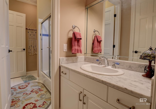 bathroom featuring tile patterned flooring, vanity, enclosed tub / shower combo, and ornamental molding