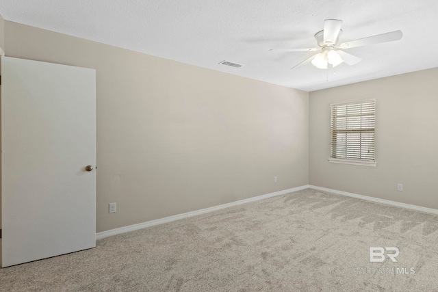 carpeted spare room with ceiling fan and a textured ceiling