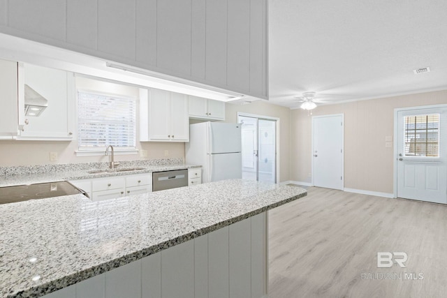 kitchen with dishwasher, light stone counters, white cabinets, white fridge, and sink