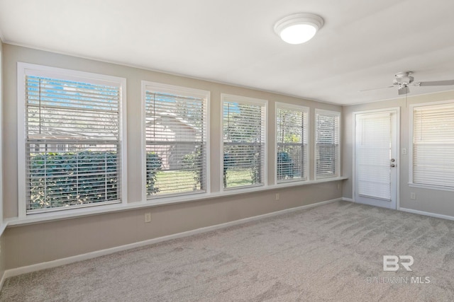 unfurnished sunroom with ceiling fan