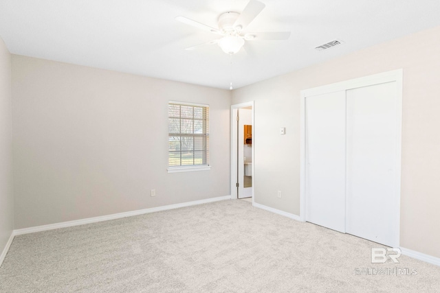 unfurnished bedroom featuring a closet, light carpet, and ceiling fan