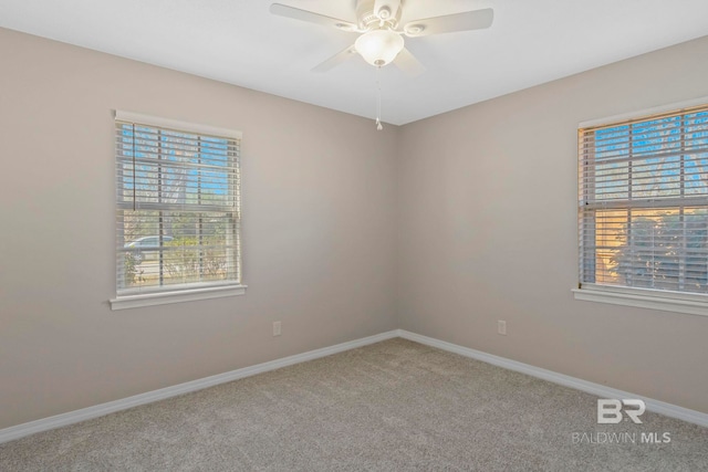 carpeted spare room featuring ceiling fan