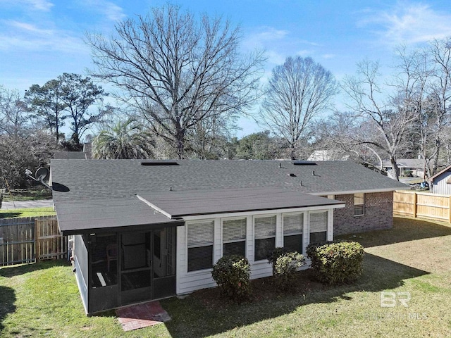 back of house featuring a yard and a sunroom