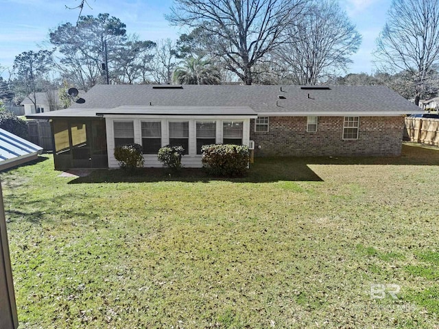 back of property with a yard and a sunroom