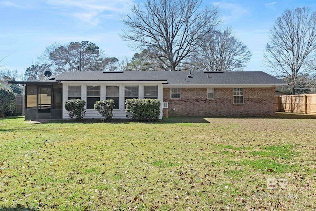 back of property with a lawn and a sunroom